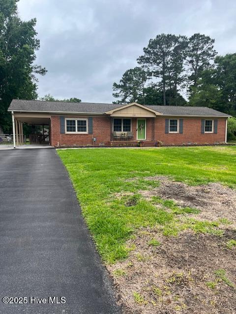 115 Oak Hills Dr, Rocky Point, NC 28457 - ranch-style home with brick siding, an attached carport, a front yard, and driveway