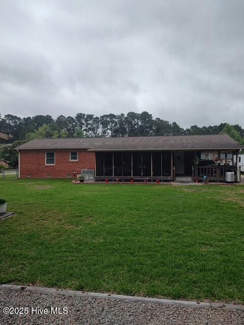 115 Oak Hills Dr, Rocky Point, NC 28457 - back of property featuring a sunroom, a lawn, and brick siding
