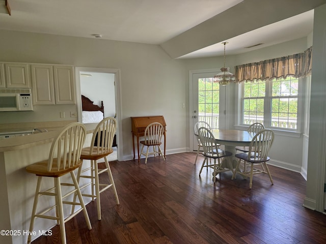 6112 Horton Rd, Oriental, NC 28571 - dining room with dark wood-style flooring, baseboards, a chandelier, and lofted ceiling