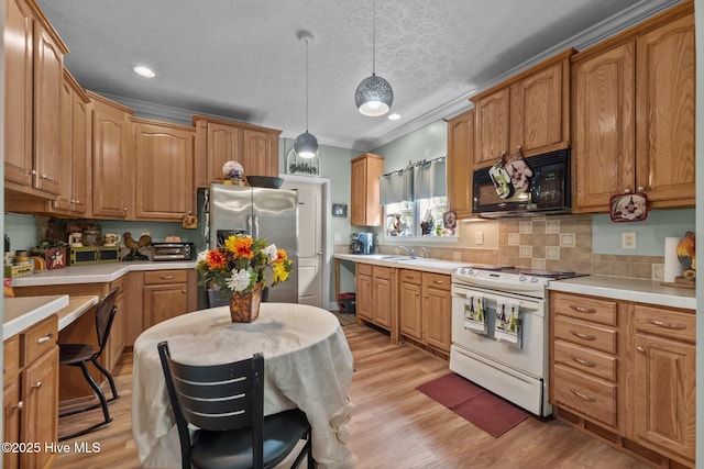 270 N Jenkins St, Holly Ridge, NC 28445 - kitchen featuring white electric range, black microwave, stainless steel refrigerator with ice dispenser, a sink, and light wood finished floors