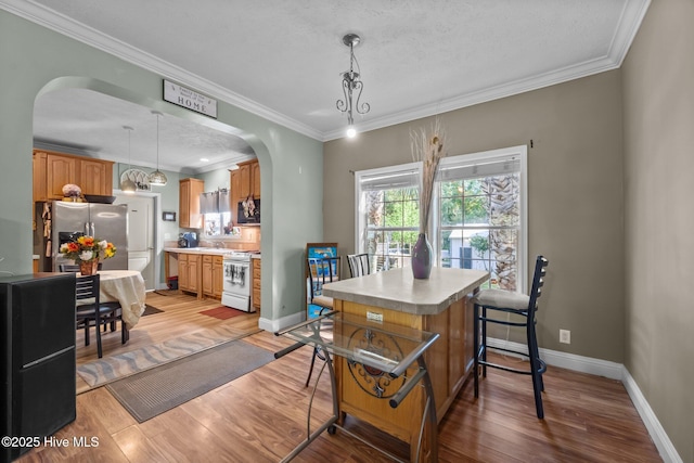 270 N Jenkins St, Holly Ridge, NC 28445 - dining area with arched walkways, light wood finished floors, ornamental molding, and baseboards