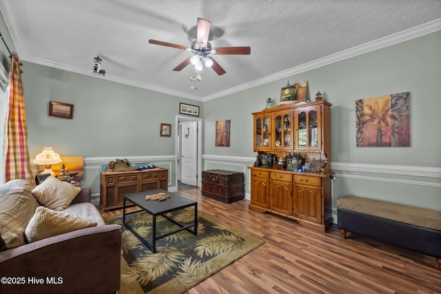 270 N Jenkins St, Holly Ridge, NC 28445 - living area with wood finished floors, a ceiling fan, crown molding, a wainscoted wall, and a textured ceiling