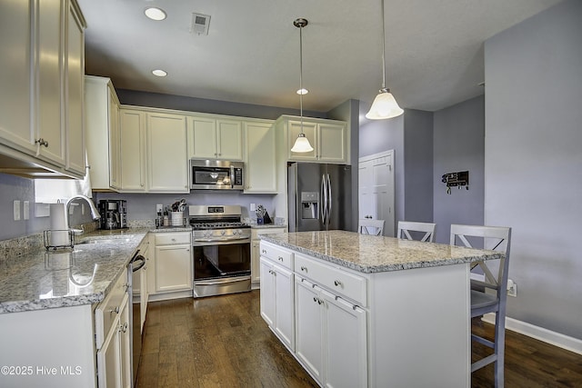 115 Elrod Rd, Moyock, NC 27958 - kitchen featuring stainless steel appliances, a breakfast bar, dark wood-style flooring, a sink, and light stone counters
