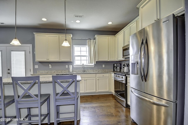 115 Elrod Rd, Moyock, NC 27958 - kitchen with stainless steel appliances, dark wood-style flooring, light stone countertops, a sink, and recessed lighting