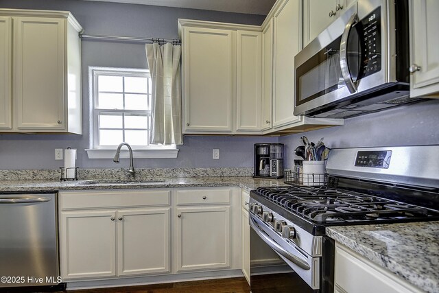 115 Elrod Rd, Moyock, NC 27958 - kitchen with stainless steel appliances, a sink, light stone counters, and white cabinets