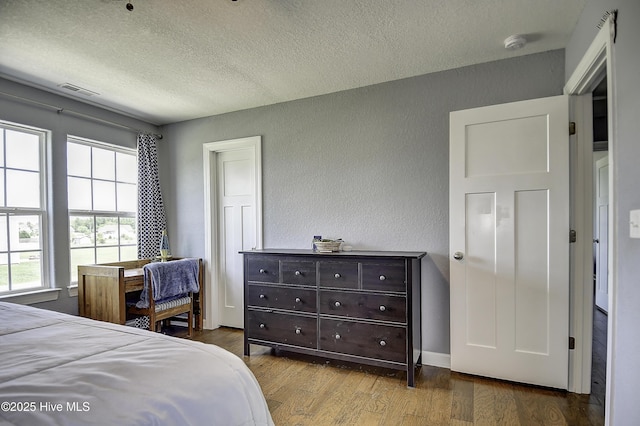 115 Elrod Rd, Moyock, NC 27958 - bedroom featuring a textured ceiling, a textured wall, wood finished floors, and baseboards