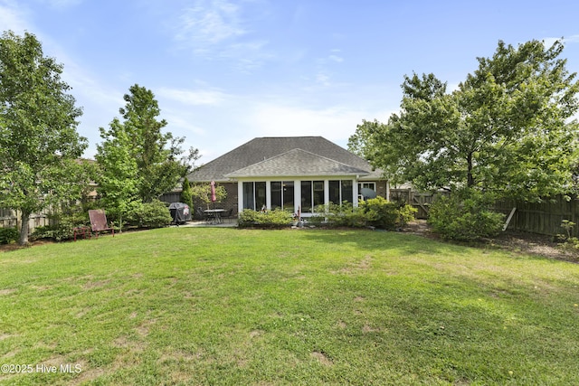 rear view of property with a sunroom and roof with shingles