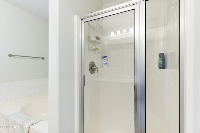 bathroom featuring a shower stall and a garden tub