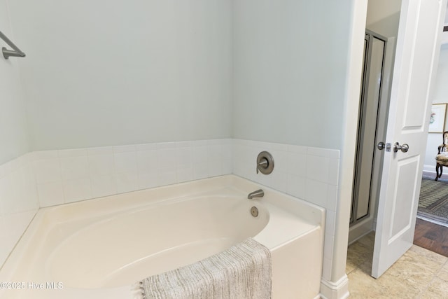 bathroom with a bath and a shower stall