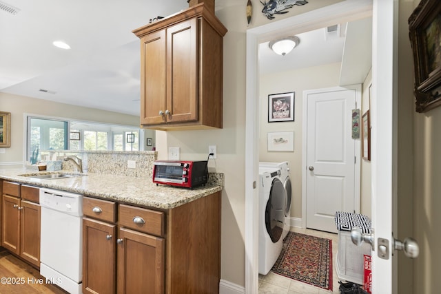 washroom featuring washing machine and clothes dryer, baseboards, and recessed lighting