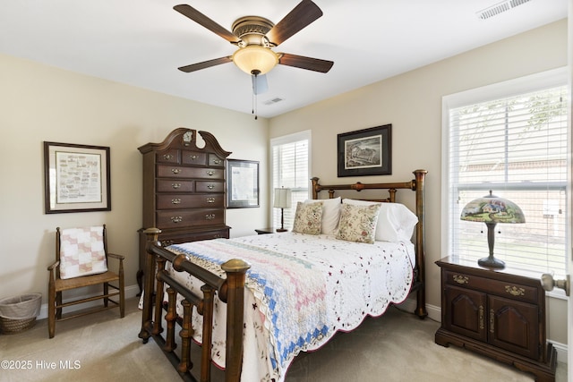 bedroom with light colored carpet, baseboards, and a ceiling fan