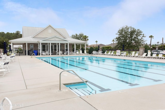 community pool with fence and a patio