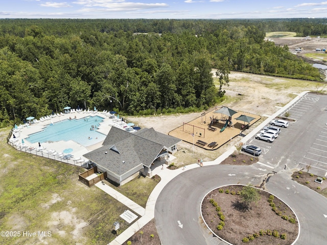 drone / aerial view of a forest and a pool