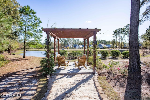 view of patio with a pergola and a water view