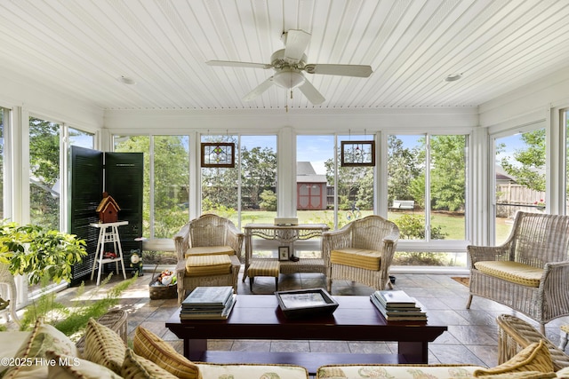 sunroom / solarium with healthy amount of natural light, outdoor lounge area, and a ceiling fan