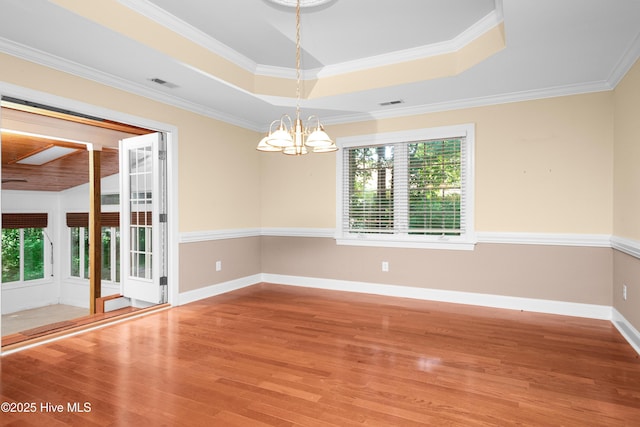 143 Rock Creek Dr, New Bern, NC 28562 - unfurnished room featuring healthy amount of natural light, wood finished floors, a chandelier, a raised ceiling, and crown molding