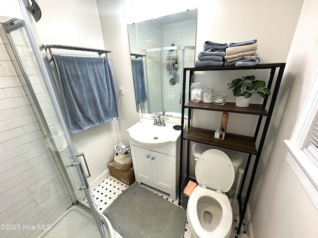 bathroom with a shower stall, vanity, and toilet