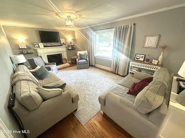 living room with crown molding, wood finished floors, a brick fireplace, and baseboards