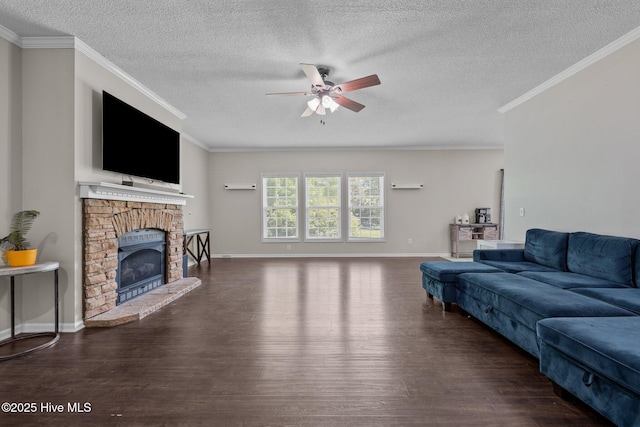 living area with wood finished floors, a ceiling fan, a textured ceiling, crown molding, and a fireplace