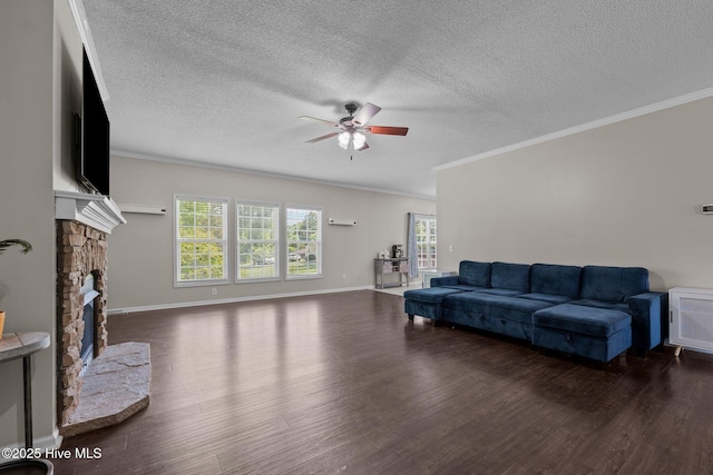 living area with a ceiling fan, ornamental molding, wood finished floors, plenty of natural light, and a fireplace with raised hearth