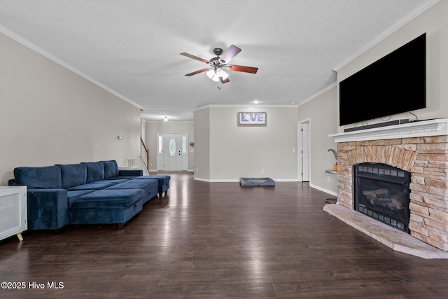 living area featuring ceiling fan, ornamental molding, wood finished floors, a fireplace with raised hearth, and stairway