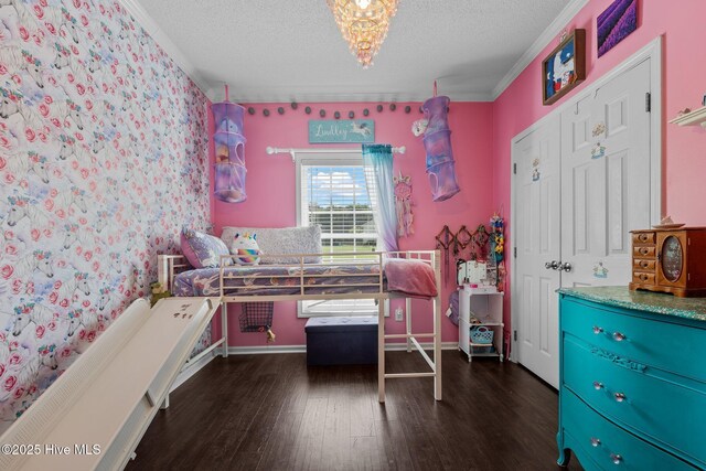 bedroom with wood finished floors, a textured ceiling, a chandelier, and crown molding