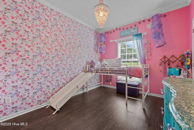 home office with wallpapered walls, crown molding, baseboards, wood finished floors, and a chandelier
