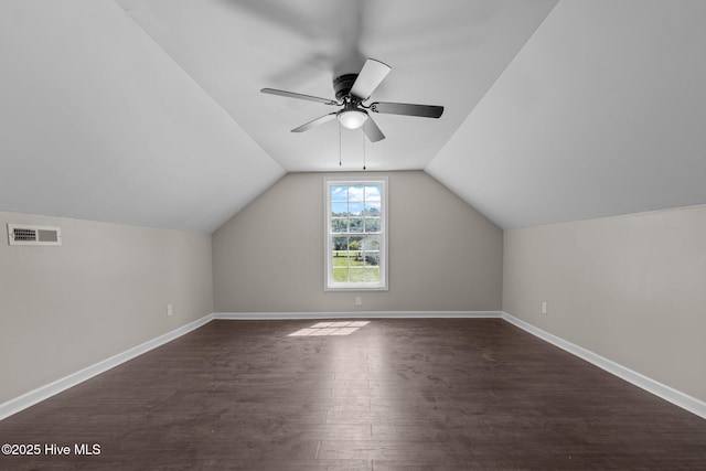 additional living space featuring dark wood finished floors, a ceiling fan, baseboards, and vaulted ceiling