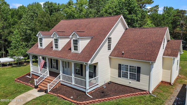 view of front facade with covered porch, a front yard, and roof with shingles