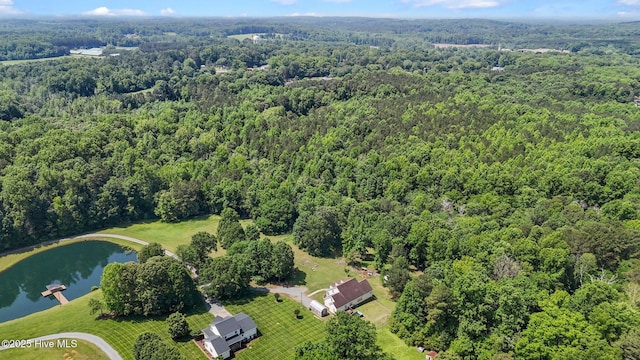 aerial view of property's location with a heavily wooded area and a nearby body of water