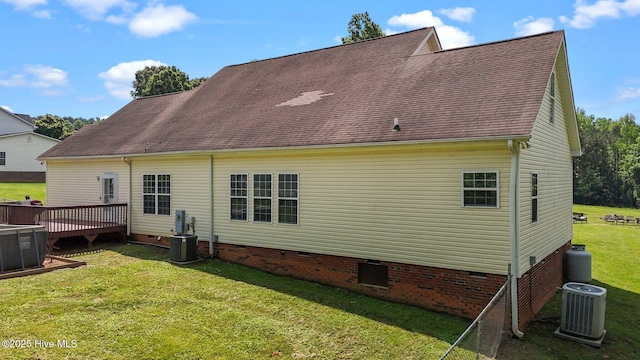 back of house with crawl space, central air condition unit, a yard, a deck, and roof with shingles