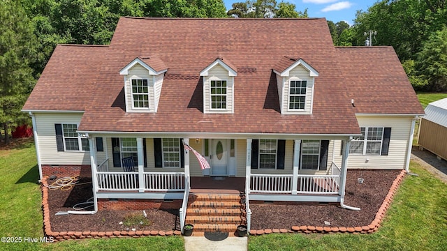 cape cod house with covered porch, a front lawn, and a shingled roof