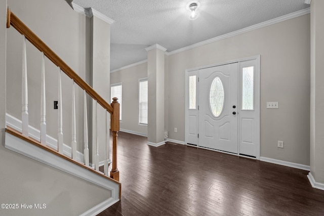 foyer entrance featuring a textured ceiling, wood finished floors, stairway, crown molding, and baseboards