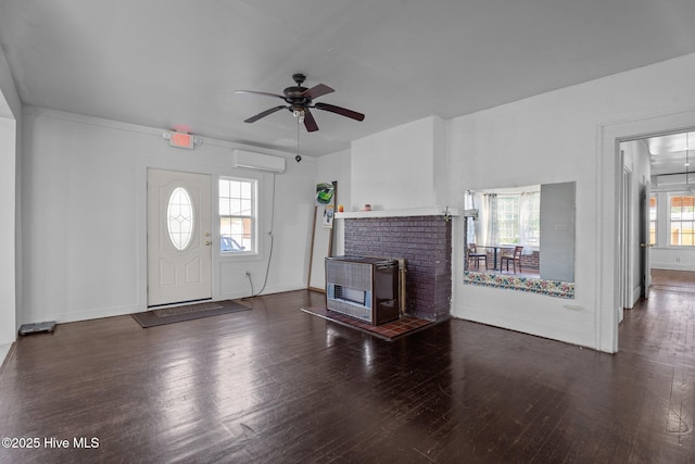 511 Herring Ave NE, Wilson, NC 27893 - unfurnished living room featuring a wall unit AC, a ceiling fan, wood finished floors, and baseboards