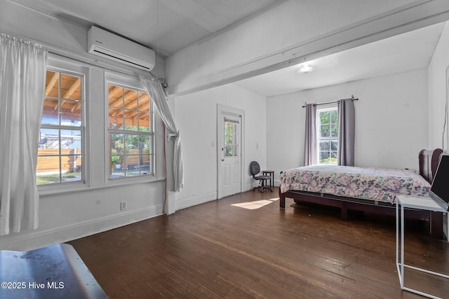 511 Herring Ave NE, Wilson, NC 27893 - bedroom featuring an AC wall unit, hardwood / wood-style flooring, and baseboards