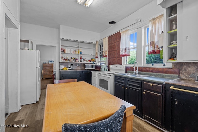 511 Herring Ave NE, Wilson, NC 27893 - kitchen featuring white appliances, open shelves, a sink, dark countertops, and light wood finished floors