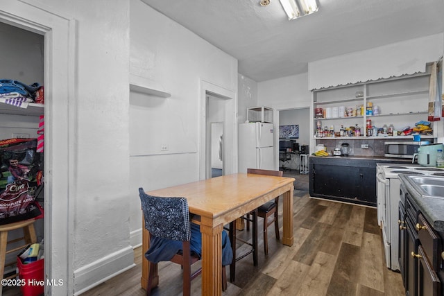 511 Herring Ave NE, Wilson, NC 27893 - kitchen featuring freestanding refrigerator, stainless steel microwave, open shelves, and dark wood-style floors