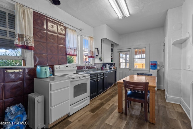 511 Herring Ave NE, Wilson, NC 27893 - kitchen featuring white electric range oven, radiator heating unit, a sink, dark wood-type flooring, and open shelves