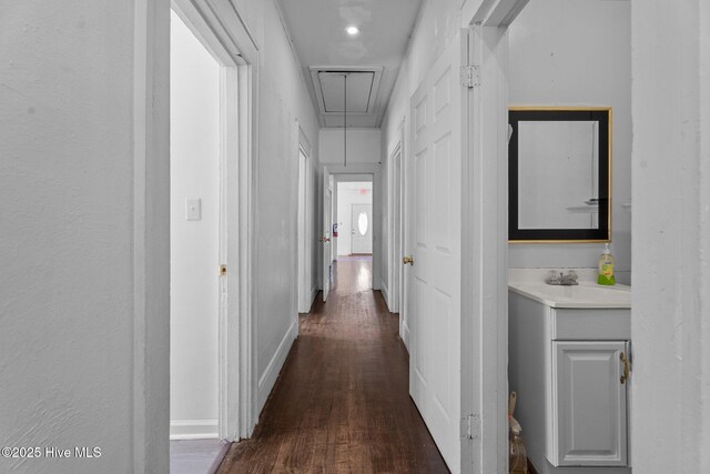 511 Herring Ave NE, Wilson, NC 27893 - corridor with attic access, dark wood-type flooring, a sink, and baseboards