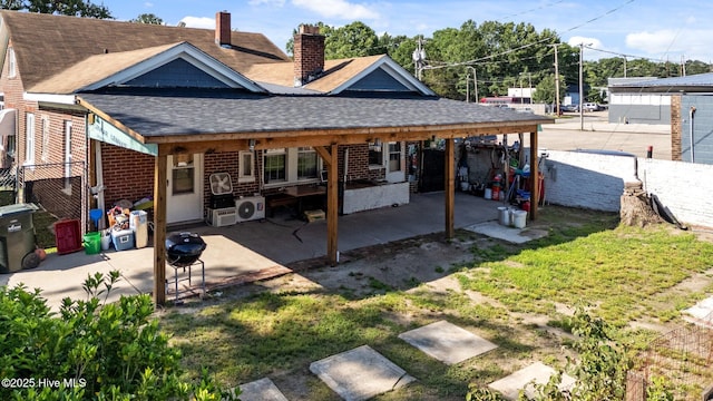 511 Herring Ave NE, Wilson, NC 27893 - rear view of property featuring a shingled roof, a patio, a chimney, and brick siding