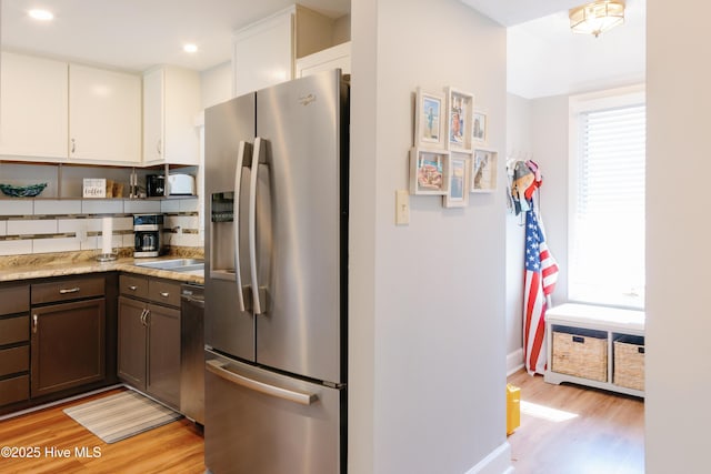 131 Paddle Wheel Cir, Washington, NC 27889 - kitchen with appliances with stainless steel finishes, light wood finished floors, white cabinetry, tasteful backsplash, and dark brown cabinets