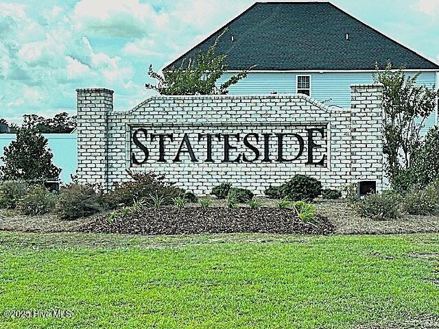 community / neighborhood sign with a yard