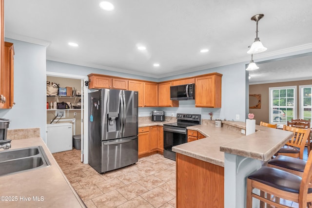 kitchen featuring appliances with stainless steel finishes, washer / clothes dryer, a sink, a peninsula, and light countertops
