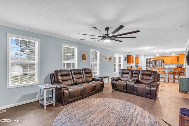 living area with crown molding, a ceiling fan, baseboards, light wood-style floors, and a textured ceiling