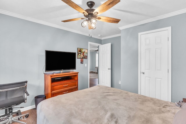 bedroom featuring wood finished floors, crown molding, baseboards, and a ceiling fan
