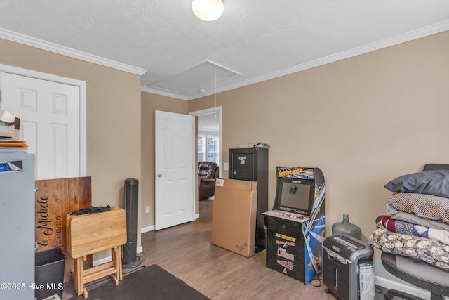 office featuring attic access, wood finished floors, crown molding, and baseboards