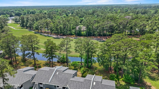 drone / aerial view of a large body of water, a golf club, and a forest