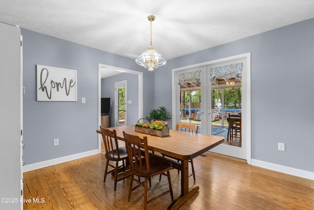 122 Bradley Pines Dr, Wilmington, NC 28403 - dining room featuring french doors, baseboards, light wood-style floors, and a chandelier