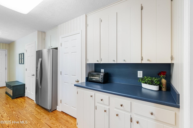 122 Bradley Pines Dr, Wilmington, NC 28403 - kitchen with stainless steel refrigerator with ice dispenser, a textured ceiling, white cabinets, light wood-type flooring, and dark countertops