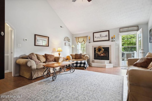 1177 Roberts Rd, Newport, NC 28570 - living room with healthy amount of natural light, a tile fireplace, high vaulted ceiling, ceiling fan, and wood finished floors